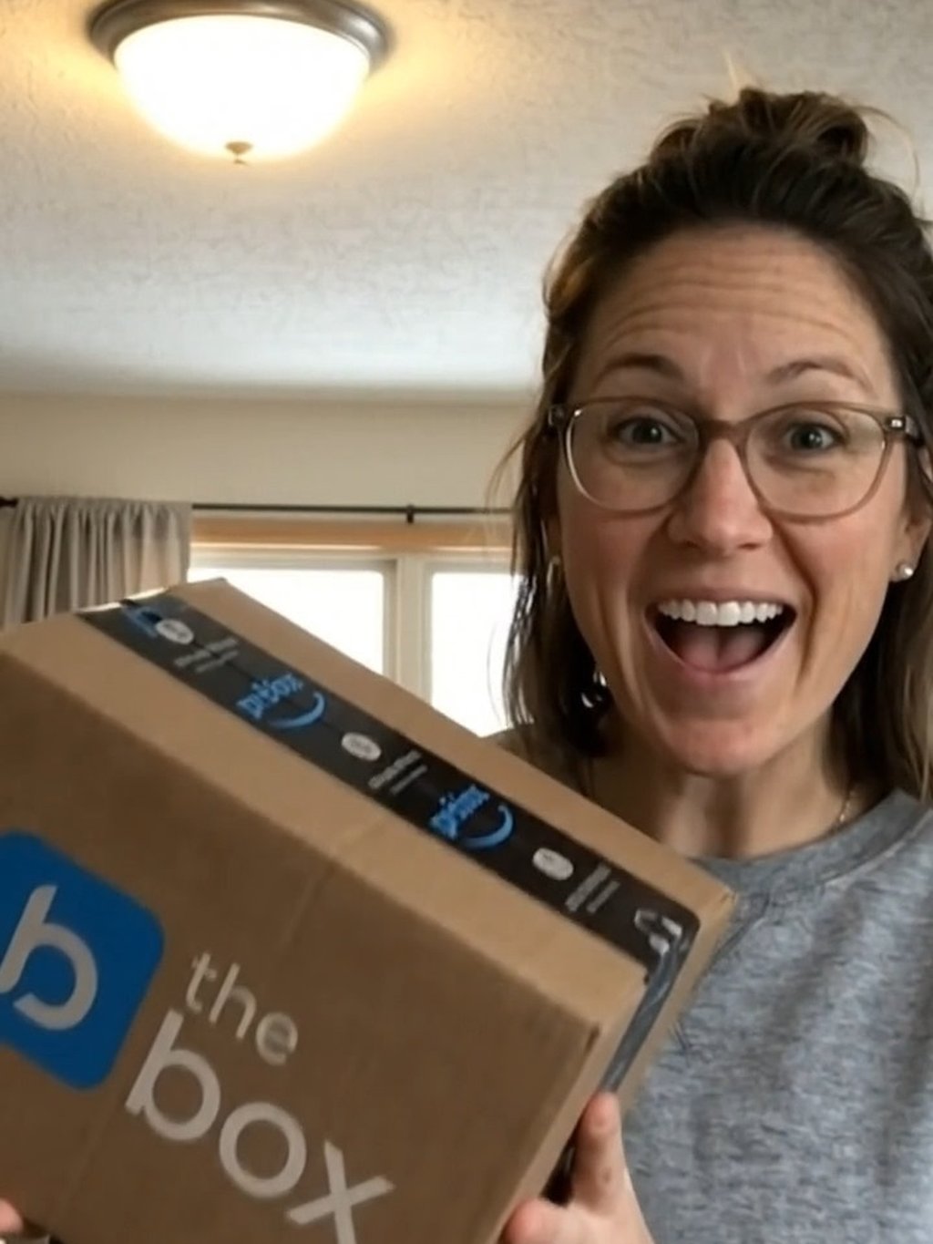 Cliente sorrindo ao segurar a caixa da The Box recém-recebida