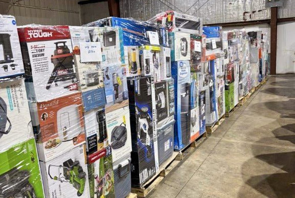 Corredor de armazém com paletes altos de caixas de eletrodomésticos e eletrônicos envelopados em plástico